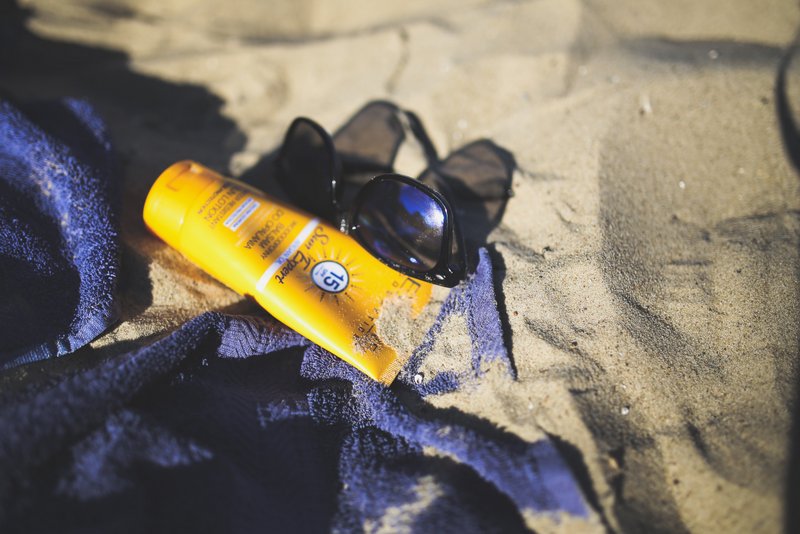 Sand, sunglasses and sunblock - free summer stock photo